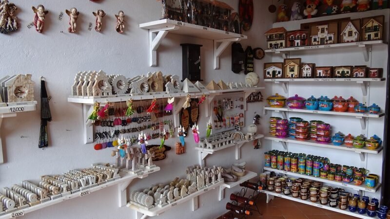 Estantes con artesanías, recuerdos y productos organizados por categorías en un comercio de Barichara, Santander