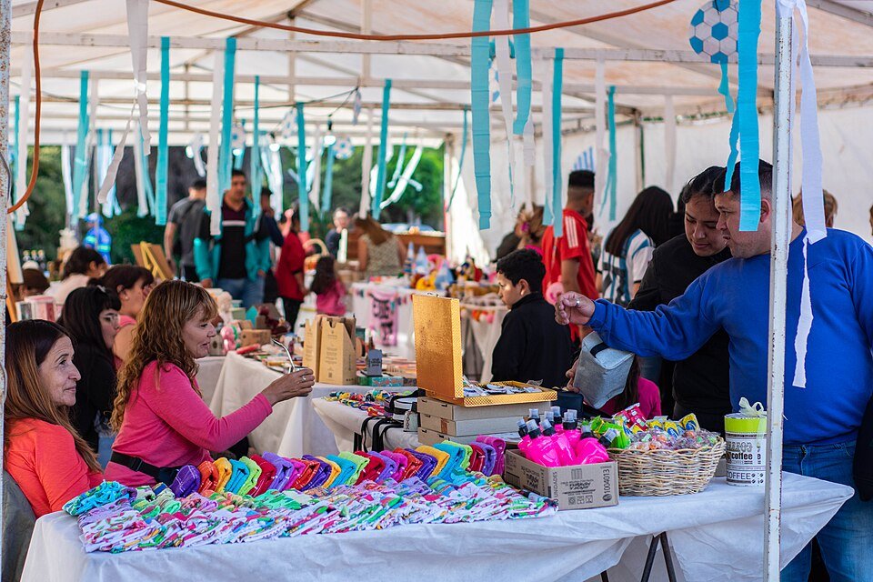 Puestos y visitantes de una feria comercial como referencia para emprendedores